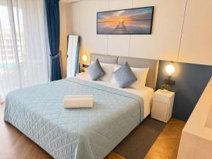 a bedroom with a large bed with blue pillows at The Sunshine Beach Resort Studio in Layan Beach