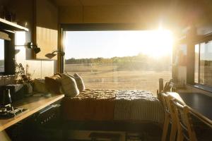 a bedroom with a view of a field through a window at Heyscape Busselton in Busselton