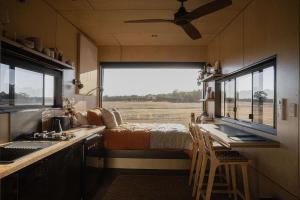 a kitchen with a bed and a sink and a window at Heyscape Busselton in Busselton