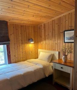 a bedroom with a bed with a wooden ceiling at Reine Harbour Cabins in Moskenes