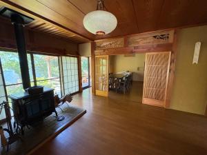a living room with a fireplace and a dining room at Yamaneko Lodge in Gujo