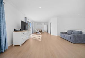 a living room with a couch and a tv at Stunning Waterfront Escape in Gold Coast