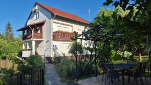 a house with a table and chairs in front of it at Rooms Garden in Slunj