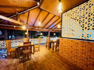 a restaurant with wooden tables and chairs and a brick wall at Secret Gem in Arugam Bay