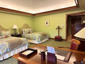 a hotel room with two beds and a desk with a desk at The Rose Hotel in Pleasanton