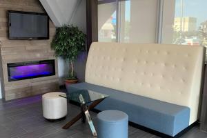 a living room with a couch and a tv at Howard Johnson by Wyndham Oklahoma City OKC Airport, Near Fairgrounds, I40, Free Hot Breakfast, and Pool in Oklahoma City