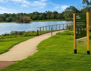 a sign next to a path next to a lake at Bellarine Breeze in Drysdale