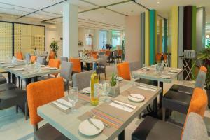 a restaurant with tables and chairs with plates and wine glasses at Microtel by Wyndham UP Technohub in Manila