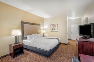 a hotel room with a bed and a flat screen tv at La Quinta by Wyndham Vicksburg in Vicksburg