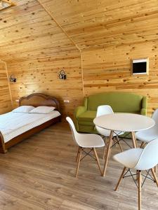 a bedroom with a bed and two tables and chairs at Барнхаус in Cholpon-Ata