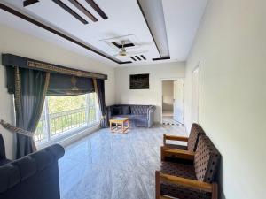 a living room with a couch and a window at EmberGuestHouse in Abbottabad
