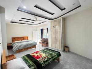 a bedroom with a bed and a chair in it at EmberGuestHouse in Abbottabad