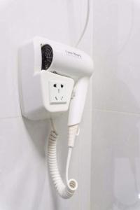 a white phone on a wall in a bathroom at Khemra Guesthouse in Kampot in Kampot