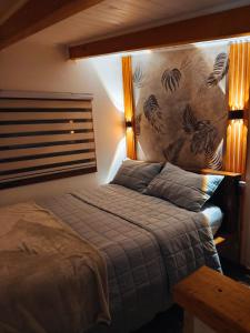 a bedroom with a bed and a wall with a mural at Casa Arrayan in Coñaripe
