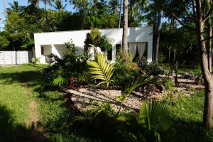 a white house with plants in front of it at Nyotas gem in Watamu