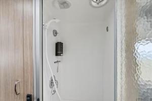 a shower in a bathroom with a glass door at Yosemite's Best Glamping Airstream Experience! in Coarsegold
