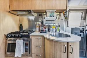 a kitchen with a sink and a stove in an rv at Yosemite's Best Glamping Airstream Experience! in Coarsegold