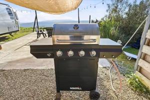 a grill sitting on a stand in a yard at Yosemite's Best Glamping Airstream Experience! in Coarsegold +20 photos