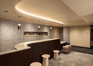 a lobby with a counter and stools at B:CONTE Asakusa in Tokyo