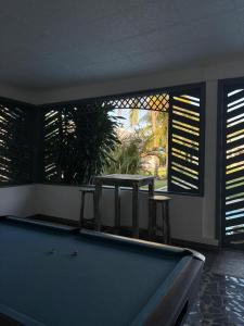 a billiard room with a pool table and a window at Stella Rina "Adults Only" in Grand-Baie