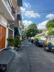 a street with a bench on the side of a building at Pineapple Express hostel at BKK in Bang Bua Thong Railway Station