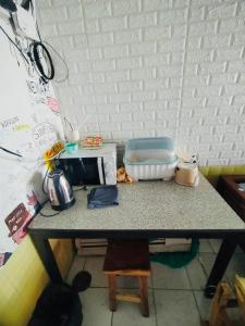 a counter top with a microwave and a toaster on it at Pineapple Express hostel at BKK in Bang Bua Thong Railway Station