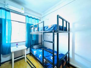 a room with two bunk beds and a desk at Pineapple Express hostel at BKK in Bang Bua Thong Railway Station