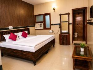 a bedroom with a bed with red pillows and a mirror at Hotel Goverdhan - Walking to Raja Ki Mandi Railway and 3km from ISBT in Agra