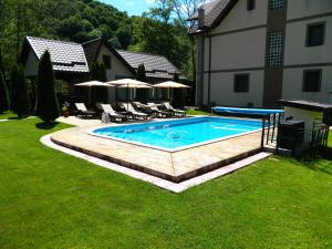a swimming pool in a yard next to a house at Alpenhaus in Voineasa