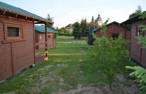 a yard with a row of wooden buildings at Domki U Grega na kaszubach in Wiele