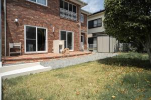 a brick house with a yard in front of it at Nagano Villa 翠 in Nagano