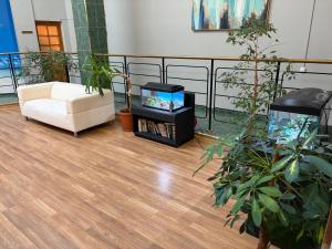 a living room with a white couch and a fish tank at Narva Center Aparthotel in Narva