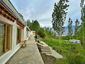 a house with a pathway leading to a yard with benches at Lharje Resort in Satti