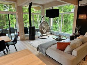 a living room with a couch and a table and chairs at Le RuissO - Spa et Confort in Brownsburg