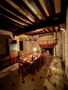 a dining room with a table and chairs and a fireplace at Donjon de Saintines - gîte 6 adultes 3 enfants - monument historique in Saintines