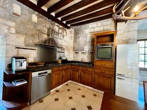 a kitchen with wooden cabinets and a white refrigerator at Donjon de Saintines - gîte 6 adultes 3 enfants - monument historique in Saintines +29 photos