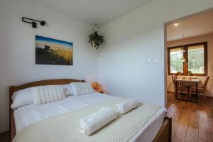 a bedroom with a bed with white sheets and a table at Leśne Apartamenty in Bobolice