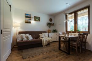 a living room with a couch and a table at Leśne Apartamenty in Bobolice