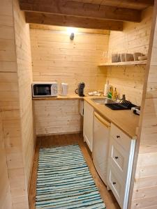 a small kitchen with a sink and a microwave at Puhkemökk in Sõmera