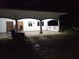 a person walking in front of a house at night at Mtf Homestay in Baling