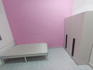 a room with a bench and a pink wall at Mtf Homestay in Baling