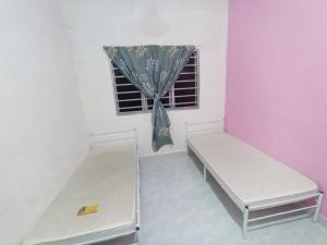 a room with two beds and a window at Mtf Homestay in Baling