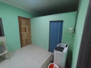 a room with a door and a room with green walls at Mtf Homestay in Baling