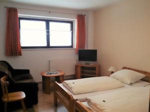 a small room with two beds and a window at Waldhotel Zöbischhaus in Bad Reiboldsgrün