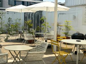 a group of tables and chairs with white umbrellas at Hotel Le'O in Seoul