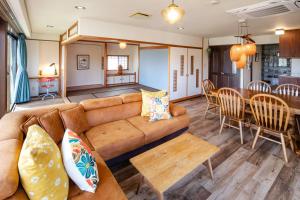 a living room and dining room with a couch and a table at Mitte Misono Apartments in Sapporo