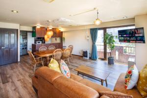 a living room with a couch and a table at Mitte Misono Apartments in Sapporo
