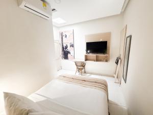 a white room with a bed and a tv at Casa Helena Hotel Centro Historico in Cartagena de Indias