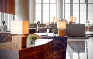 a lobby with a woman sitting at a desk at Park Hyatt Guangzhou in Guangzhou