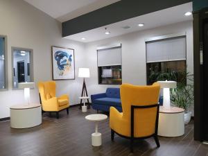 a lobby with a blue couch and two yellow chairs at Comfort Inn near Downtown & Blue Ridge PKWY in Marion +69 photos